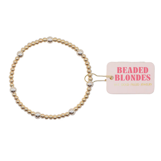 Gold and silver beaded bracelet with a 'Beaded Blondes' tag on a white background