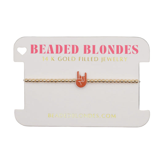 Gold bracelet on a 'Beaded Blondes' branded card with a white background