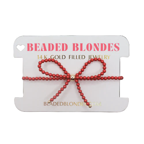 Red beaded bracelet on a 'Beaded Blondes' branded card with gold accents.