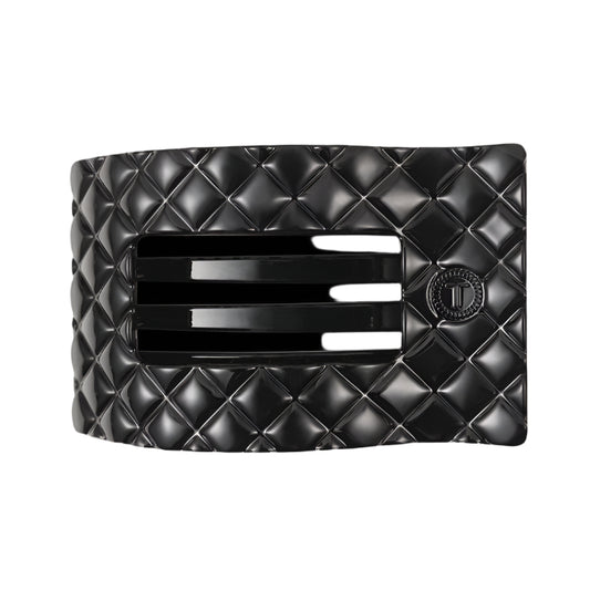 Black quilted hair clip with a brand logo on a white background