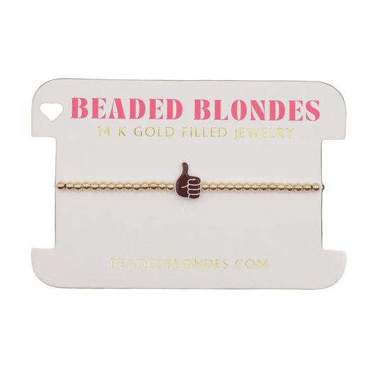 Gold bracelet on a 'Beaded Blondes' branded card with a white background