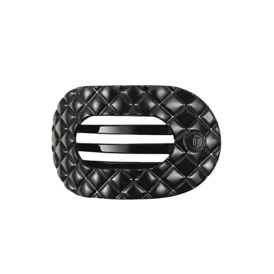 Black quilted hair clip with a brand logo on a white background
