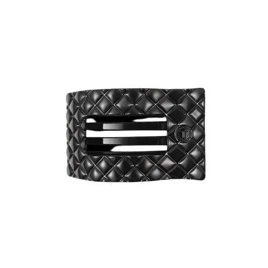Black quilted hair clip with a brand logo on a white background
