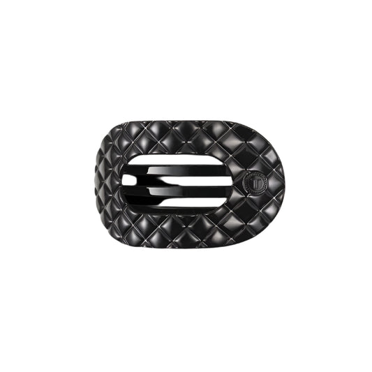 Black quilted hair clip with a brand logo on a white background
