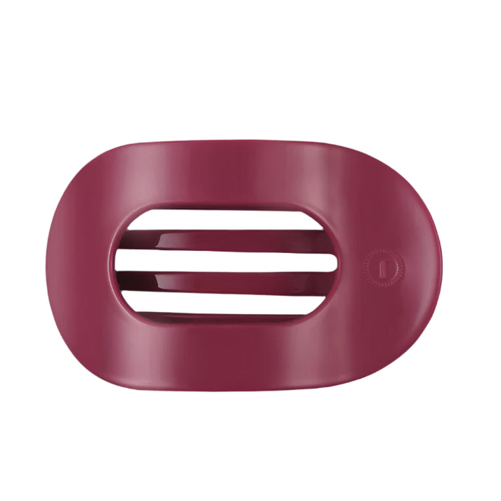 Pink hair clip with a brand logo on a white background
